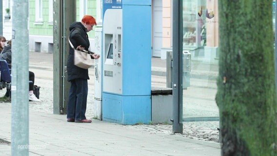 Eine Person steht am Ticketautomaten. © Screenshot 