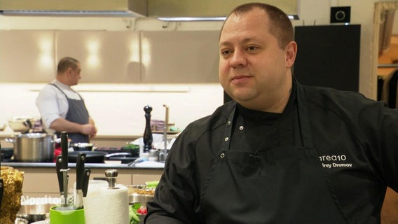 Der ukrainische Koch Andrey Dromov steht zufrieden in der Workshop-Küche. © Screenshot 