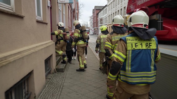 Feuerwehrleute stehen vor einem Haus in Schwerin © Screenshot 