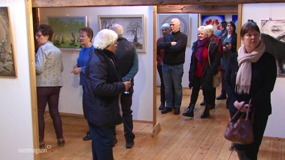 Viele Menschen stehen in einem Museum, in dem Bilder ausgestellt sind © Screenshot 