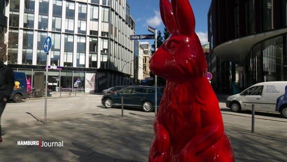 Eine rot lackierte Statue eines Hasen steht auf einem Platz in derHamburger Innenstadt. © Screenshot 