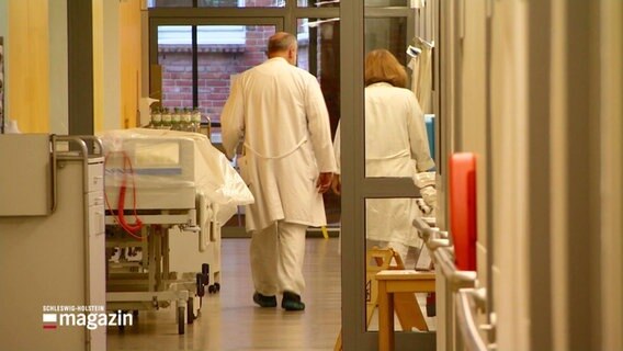 Eine Ärztin und ein Arzt gehen den Stationsflur eines Krankhauses entlang. © Screenshot 