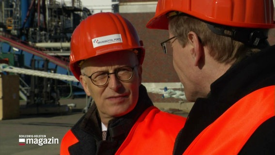 Peter Tschentscher und Daniel Günther in orangener Sicherheitskleidung. © Screenshot 