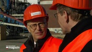 Peter Tschentscher und Daniel Günther in orangener Sicherheitskleidung. © Screenshot 