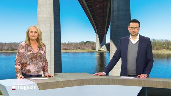 Harriet Heise und Christopher Scheffelmeier moderieren Schleswig-Holstein Magazin. Im Hintergrund ist ein Foto der Rader Hochbrücke zu sehen. © Screenshot 