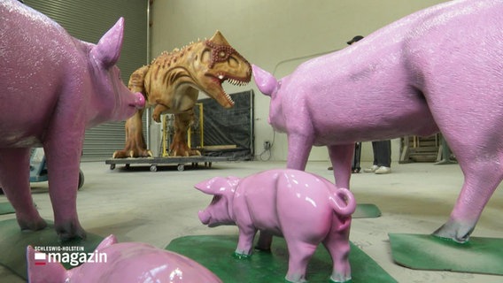 Lackierte Schweine und Dinosaurier in einer Halle. © Screenshot 