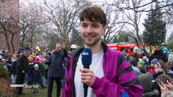 Reporter Tristan Dück steht vor vielen Besuchenden eines Osterfeuers. © Screenshot 
