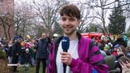 Reporter Tristan Dück steht vor vielen Besuchenden eines Osterfeuers. © Screenshot 