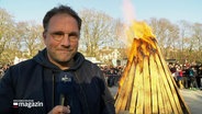 Reporter Jochen Dominicus steht vor einem brennenden Osterfeuer. © Screenshot 