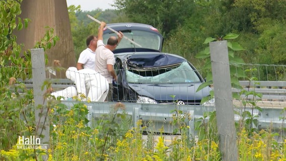 Archivbild: Mitarbeitende der Spurensicherung untersuchen ein stark beschädigtes Auto. © Screenshot 