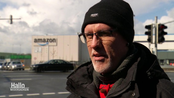 Der ehemalige Betriebsrat Rainer Reising vor einem Amazon Lager. © Screenshot 