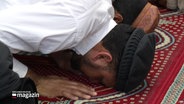 Ein Mann kniet in der Moschee auf dem Boden. © Screenshot 