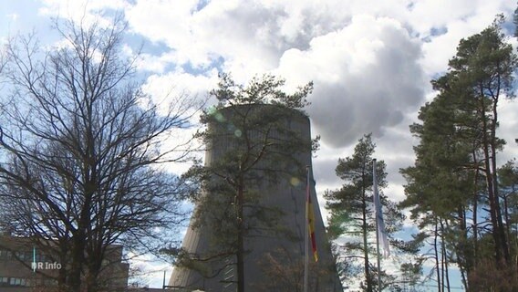 Der Kühlturm eines Atomkraftwerkes hinter Bäumen. © Screenshot 