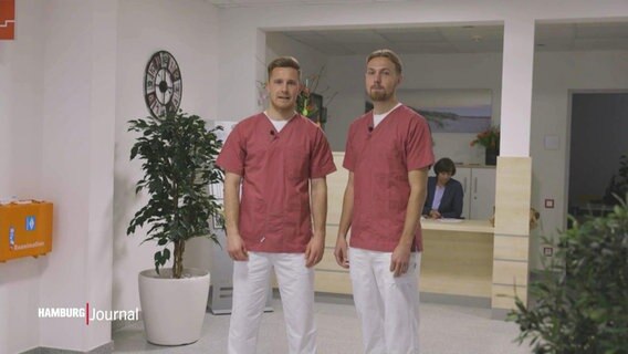Lukas Daschner und Johannes Eggestein stehen in der Kleidung von Altenpflegepersonal in einer Pflegeeinrichtung. © Screenshot 