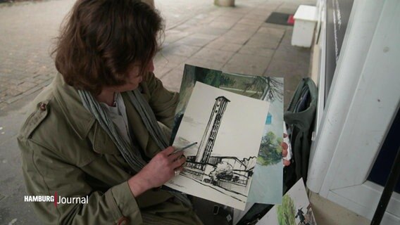 Ein Künstler zeigt auf einen gezeichneten Turm. © Screenshot 