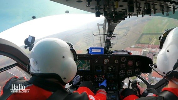 Zwei Einsatzkräfte der Luftrettung sitzen im Cockpit eines Rettungshubschraubers. © Screenshot 