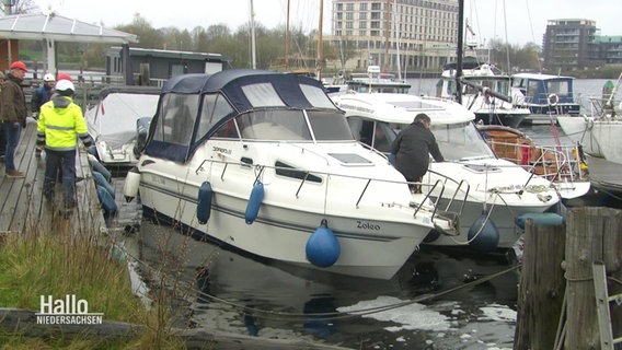 Mehrere Motoryachten liegen in einem Yachthafen an einem trüben Tag. © Screenshot 