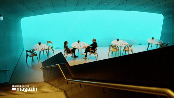 Zwei Personen sitzen im Gastraum des Unterwasserrestaurants "Under" in Norwegen. © Screenshot 
