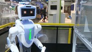 Ein Roboter an einem Messestand © Screenshot 