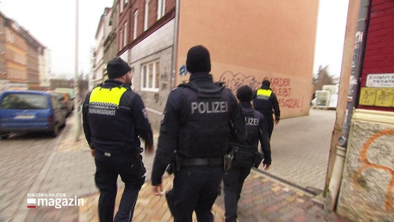 Kieler Ordnungsdienst und Polizei laufen um eine Hausecke. © Screenshot 