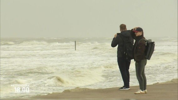 Menschen stehen bei Sturm an einer Meeresküste © Screenshot 