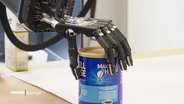 Eine Roboterhand greift eine Konservendose. © Screenshot 