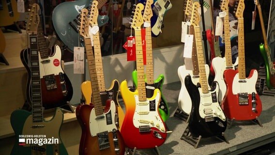 Mehrere E-Gitarren stehen in einem Laden © Screenshot 