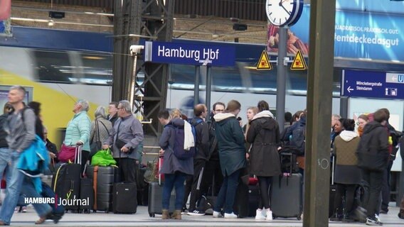 Auf einem Bahnsteig des Hamburger Hauptbahnhofs stehen mehrere Reisende mit Gepäck. © Screenshot 