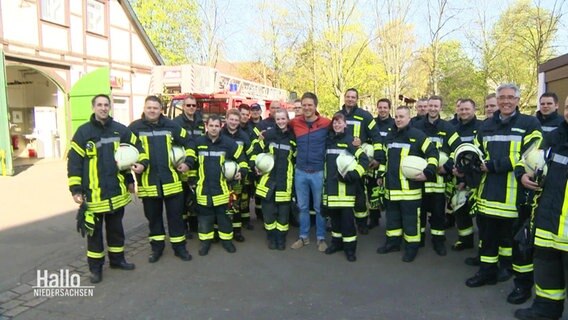 Menschen der Feuerwehr auf einer Straße versammelt © Screenshot 