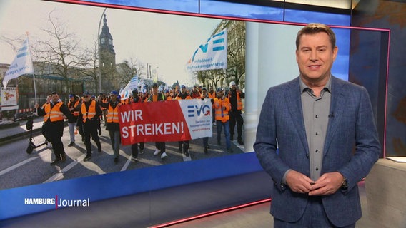Nachrichtensprecher Jens Riewa, im Hintergrund ein Bild von streikenden Bahnern. © Screenshot 