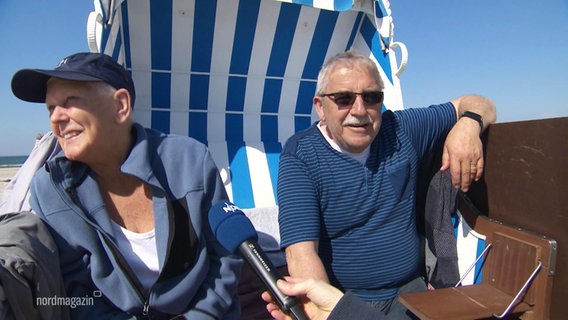 Ein Mann und eine Frau sitzen im Strandkorb und werden interviewt. © Screenshot 