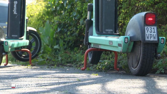 Zwei grüne E-Roller parken auf einem Bürgersteig. © Screenshot 