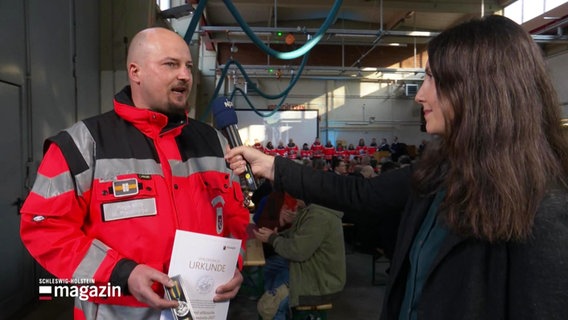 Eine NDR Reporterin interviewt einen Mann mit roter Warnjacke. © Screenshot 