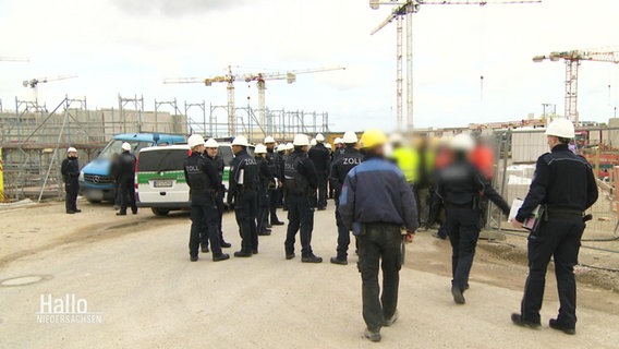 Mitarbeitende des Zolls und Bauarbeiter auf einer Großbaustelle. © Screenshot 