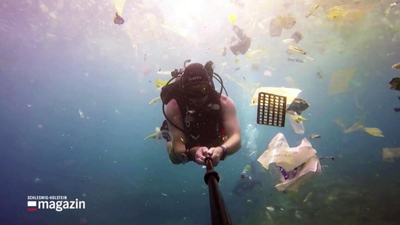 Filmszene aus dem Kurzfilm Helden der Meere: Ein Taucher im Ozean, umgeben von Plastikmüll © Screenshot 