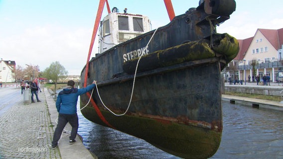 Der Schlepper "Steppke" wird aus dem Hafenbecken gehoben. © Screenshot 