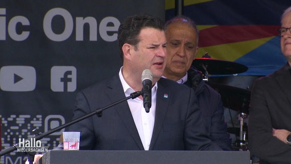 Arbeitsminister Hubertus Heil steht auf einer Bühne und spricht in ein Mikrofon. © Screenshot 