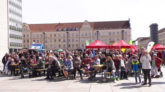 Auf einem größeren Marktplatz einer Stadt sind viele Besuchende beim Demokratiefest. © Screenshot 