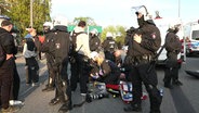 Polizeibeamtinnen stehen um eine Person, die am Boden liegt und notärztlich versorgt wird. © Screenshot 