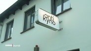 An einer Hausfassade hängt das leuchtende Schild des "Antikyno". © Screenshot 