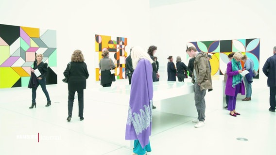 Menschen besuchen eine Ausstellung. © Screenshot 
