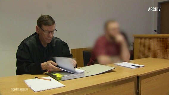Ein Angeklagter sitzt neben seinem Anwalt © Screenshot 