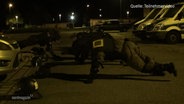 Polizisten machen nachts Sport am Boden. © Screenshot 