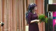 Schriftstellerin Sofi Oksanen bei der Preisverleihung des Usedomer Literaturpreises 2023. Sie hält einen Blumenstrauß in den Händen. © Screenshot 