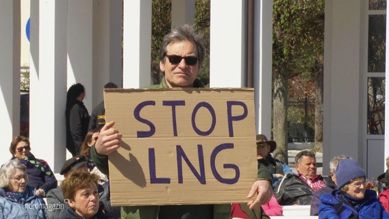 Ein Demonstrant hält ein Schild mit der Aufschrift "Stop LNG". © Screenshot 