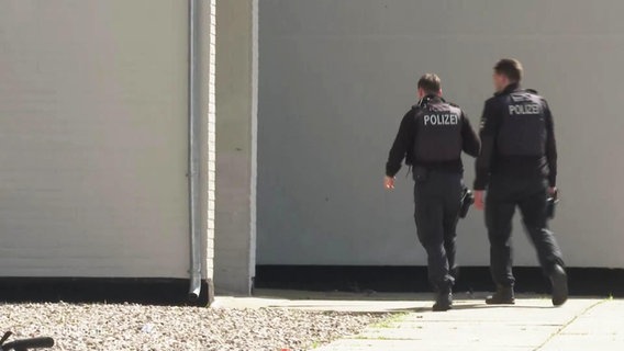 Zwei Polizeibeamte betreten ein Haus. © Screenshot 