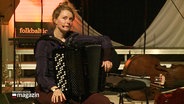 Justine Boesen sitzt mit ihrem Akkordeon auf einer Bühne. © Screenshot 