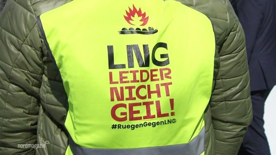 Die Rückseite einer gelben Warnweste trägt die Aufschrift: "LNG - Leider Nicht Geil". © Screenshot 