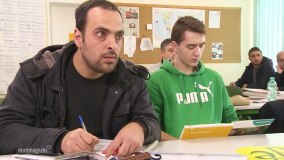 Menschen in einem Klassenraum bei einem Sprachkurs. © Screenshot 