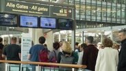 Schlangen vor der Sicherheitskontrolle am Flughafen. © Screenshot 